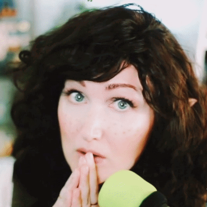A Close Up Of A Woman 'S Face With Her Hand On Her Chin GIF