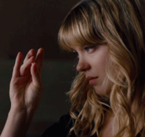 A Close Up Of A Woman 'S Face With Her Hand On Her Chin GIF
