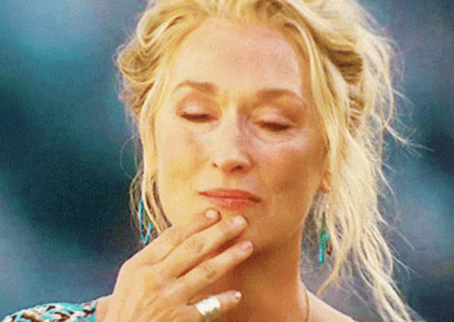 A Close Up Of A Woman 'S Face With Her Hand On Her Chin GIF