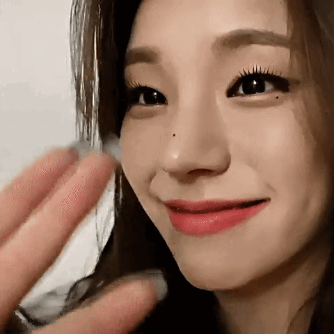 A Close Up Of A Woman 'S Face With Her Hand On Her Face And A Ring On Her Finger . GIF