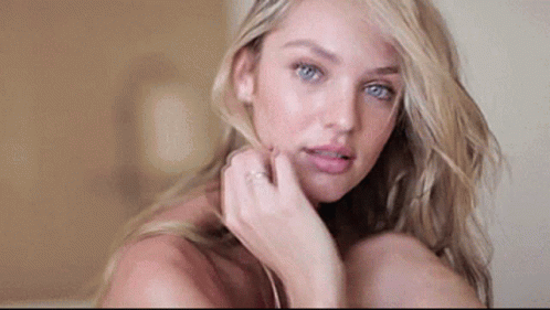 A Close Up Of A Woman 'S Face With Her Hand On Her Face And A Ring On Her Finger . GIF