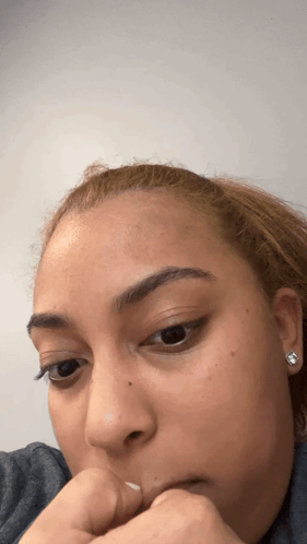 A Close Up Of A Woman 'S Face With Her Hand On Her Face GIF