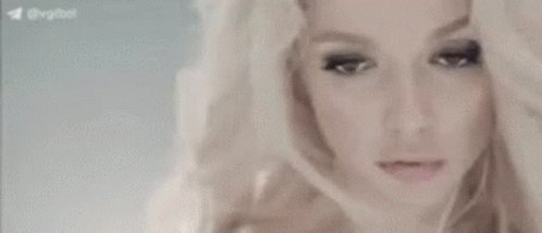 A Close Up Of A Woman 'S Face With Her Hand On Her Head . GIF