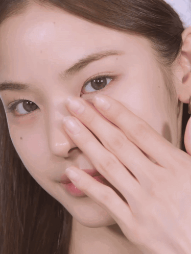 A Close Up Of A Woman 'S Face With Her Hand On It GIF