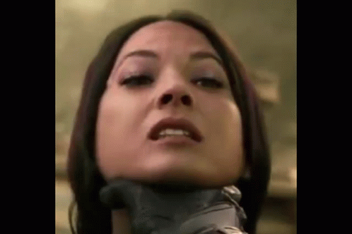 A Close Up Of A Woman 'S Face With Her Hands Around Her Neck . GIF