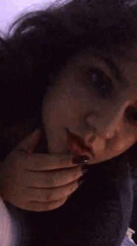 A Close Up Of A Woman 'S Face With Her Hands On Her Face . GIF