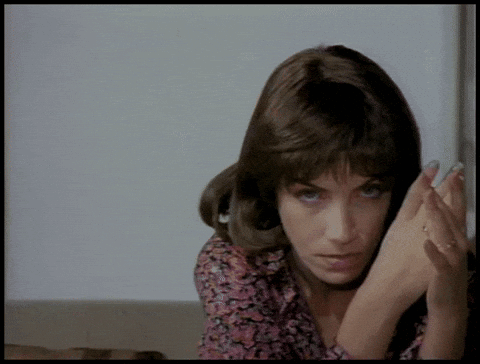 A Close Up Of A Woman 'S Face With Her Hands On Her Face GIF
