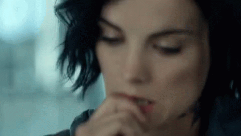 A Close Up Of A Woman 'S Face With Her Hands On Her Mouth . GIF