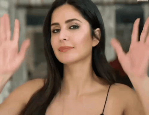 A Close Up Of A Woman 'S Face With Her Hands Outstretched . GIF