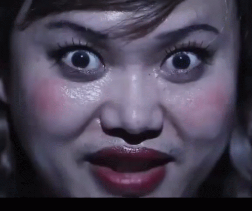 A Close Up Of A Woman 'S Face With Her Mouth Open GIF