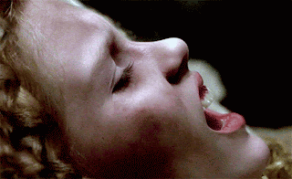 A Close Up Of A Woman 'S Face With Her Mouth Open GIF