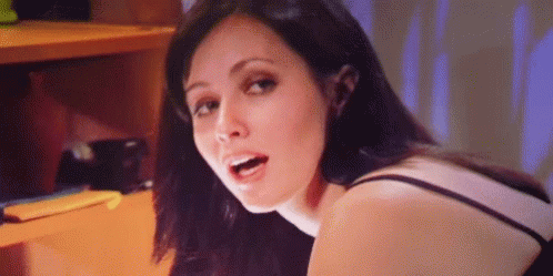 A Close Up Of A Woman 'S Face With Her Mouth Open And A Purple Background . GIF