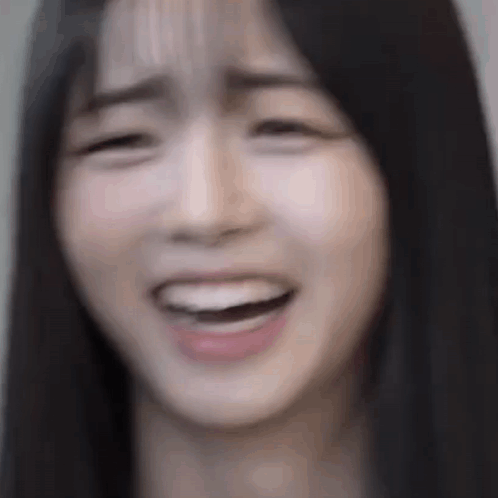 A Close Up Of A Woman 'S Face With Her Mouth Open And Her Eyes Closed . GIF