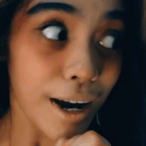 A Close Up Of A Woman 'S Face With Her Mouth Open And Her Eyes Closed . GIF