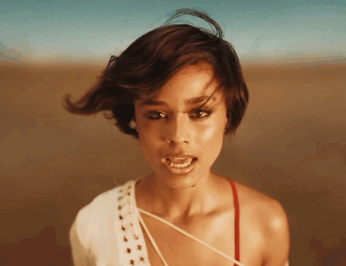 A Close Up Of A Woman 'S Face With Her Mouth Open And Her Hair Blowing In The Wind GIF