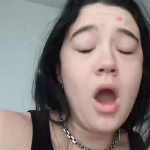 A Close Up Of A Woman 'S Face With Her Mouth Open . GIF