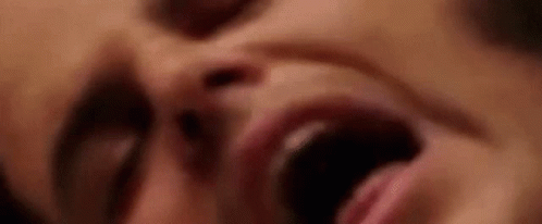 A Close Up Of A Woman 'S Face With Her Mouth Wide Open . GIF