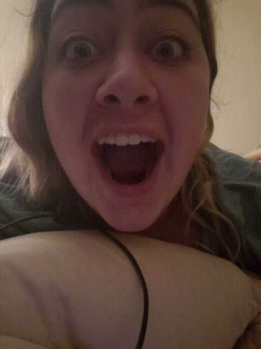 A Close Up Of A Woman 'S Face With Her Mouth Wide Open GIF