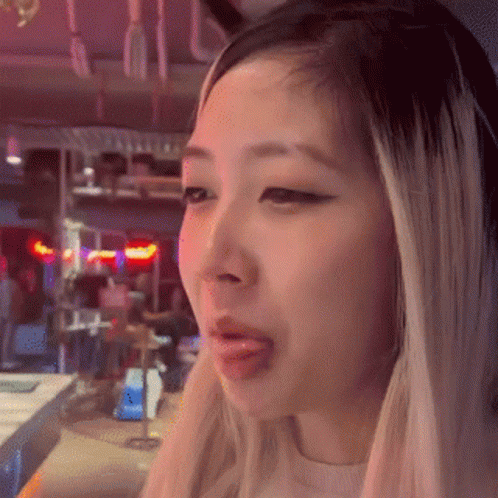 A Close Up Of A Woman 'S Face With Her Tongue Hanging Out . GIF