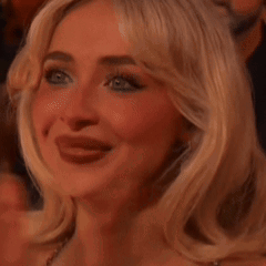 A Close Up Of A Woman 'S Face With Her Tongue Hanging Out While Applauding . GIF