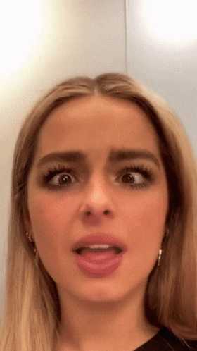 A Close Up Of A Woman 'S Face With Her Tongue Out GIF