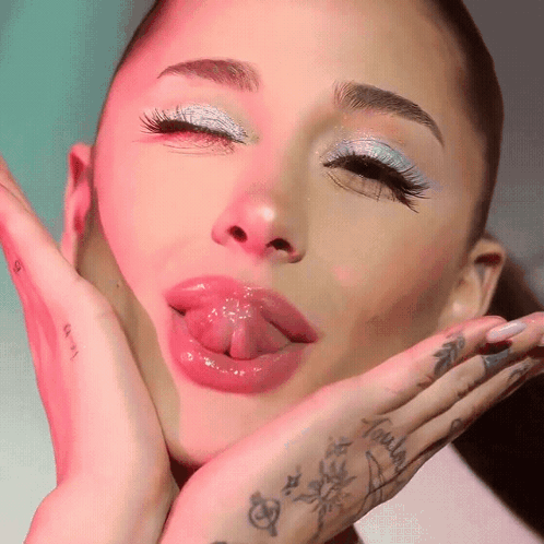 A Close Up Of A Woman 'S Face With Her Tongue Out GIF