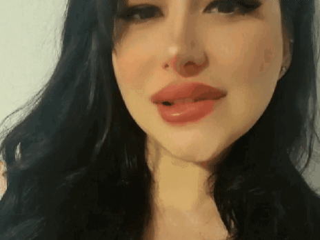 A Close Up Of A Woman 'S Face With Her Tongue Out . GIF
