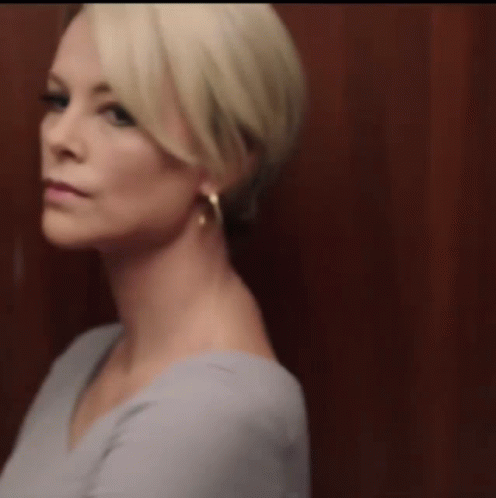 A Close Up Of A Woman 'S Face With Hoop Earrings GIF