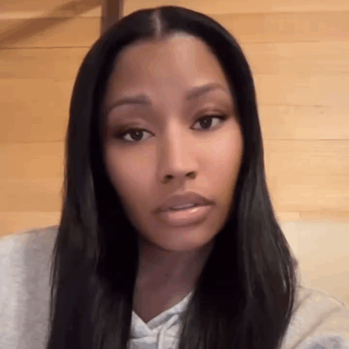 A Close Up Of A Woman 'S Face With Long Black Hair And A Serious Look On Her Face . GIF
