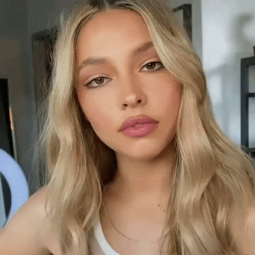A Close Up Of A Woman 'S Face With Long Blonde Hair . GIF