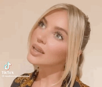 A Close Up Of A Woman 'S Face With Long Blonde Hair . GIF