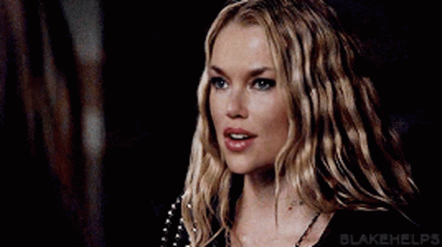A Close Up Of A Woman 'S Face With Long Blonde Hair And A Necklace . GIF