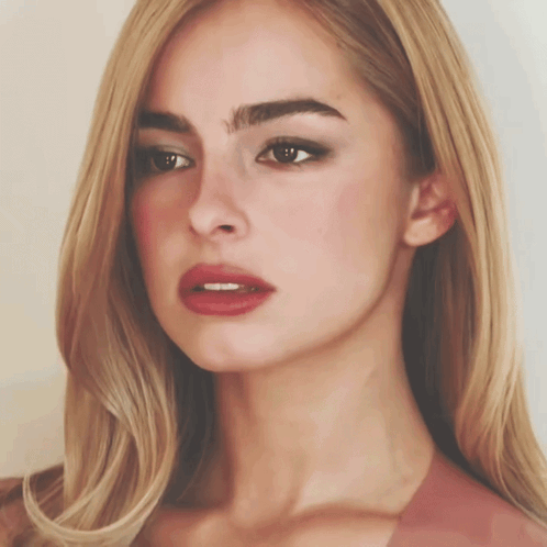 A Close Up Of A Woman 'S Face With Long Blonde Hair And Red Lips GIF