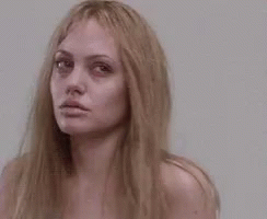 A Close Up Of A Woman 'S Face With Long Blonde Hair Without Makeup . GIF