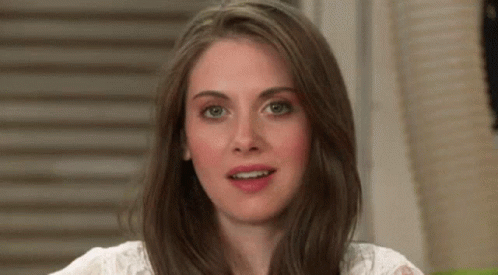 A Close Up Of A Woman 'S Face With Long Brown Hair And A White Shirt . GIF