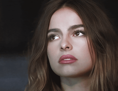 A Close Up Of A Woman 'S Face With Long Brown Hair GIF