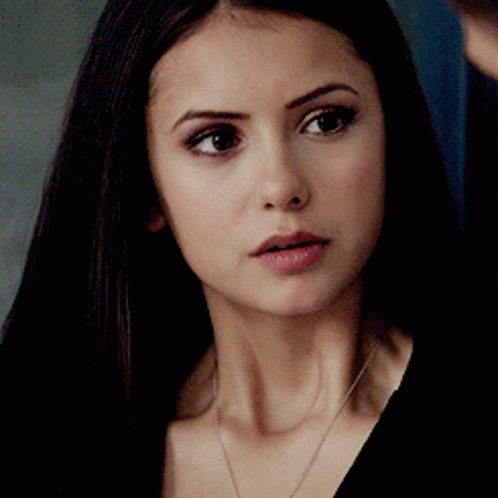 A Close Up Of A Woman 'S Face With Long Dark Hair GIF