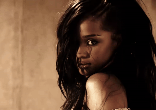 A Close Up Of A Woman 'S Face With Long Dark Hair GIF