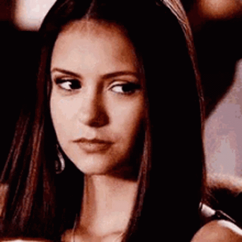 A Close Up Of A Woman 'S Face With Long Hair And A Serious Look On Her Face . GIF