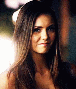 A Close Up Of A Woman 'S Face With Long Hair And A Smile . GIF