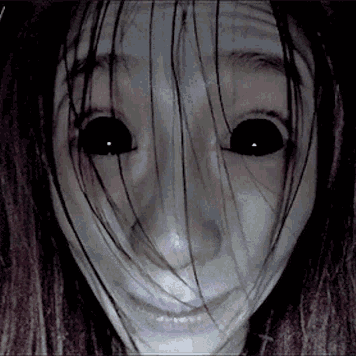 A Close Up Of A Woman 'S Face With Long Hair And Black Eyes . GIF