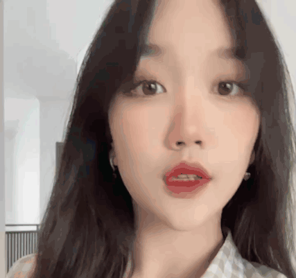 A Close Up Of A Woman 'S Face With Long Hair And Red Lips GIF