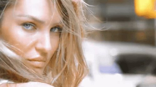 A Close Up Of A Woman 'S Face With Long Hair Blowing In The Wind . GIF