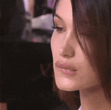 A Close Up Of A Woman 'S Face With Long Hair GIF
