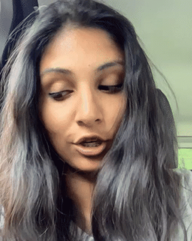 A Close Up Of A Woman 'S Face With Long Hair GIF