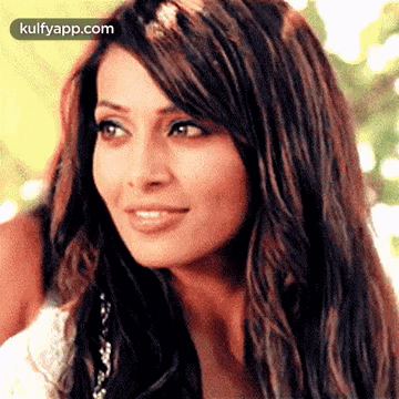 A Close Up Of A Woman 'S Face With Long Hair Looking At The Camera . GIF