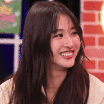 A Close Up Of A Woman 'S Face With Long Hair Smiling . GIF