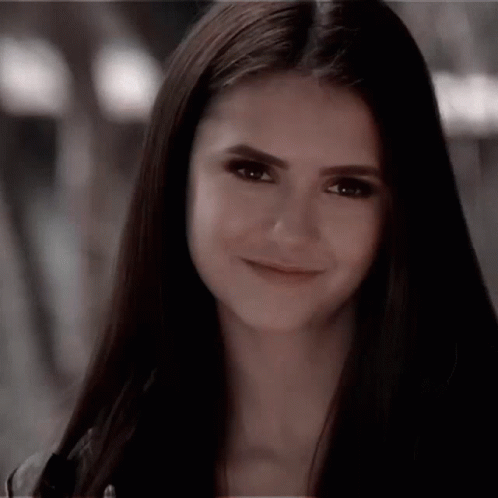 A Close Up Of A Woman 'S Face With Long Hair Smiling . GIF