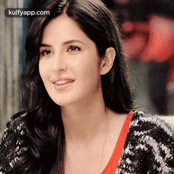 A Close Up Of A Woman 'S Face With Long Hair Wearing A Black And White Sweater . GIF