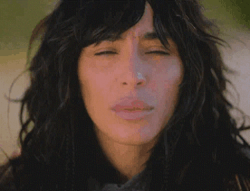 A Close Up Of A Woman 'S Face With Long Hair GIF